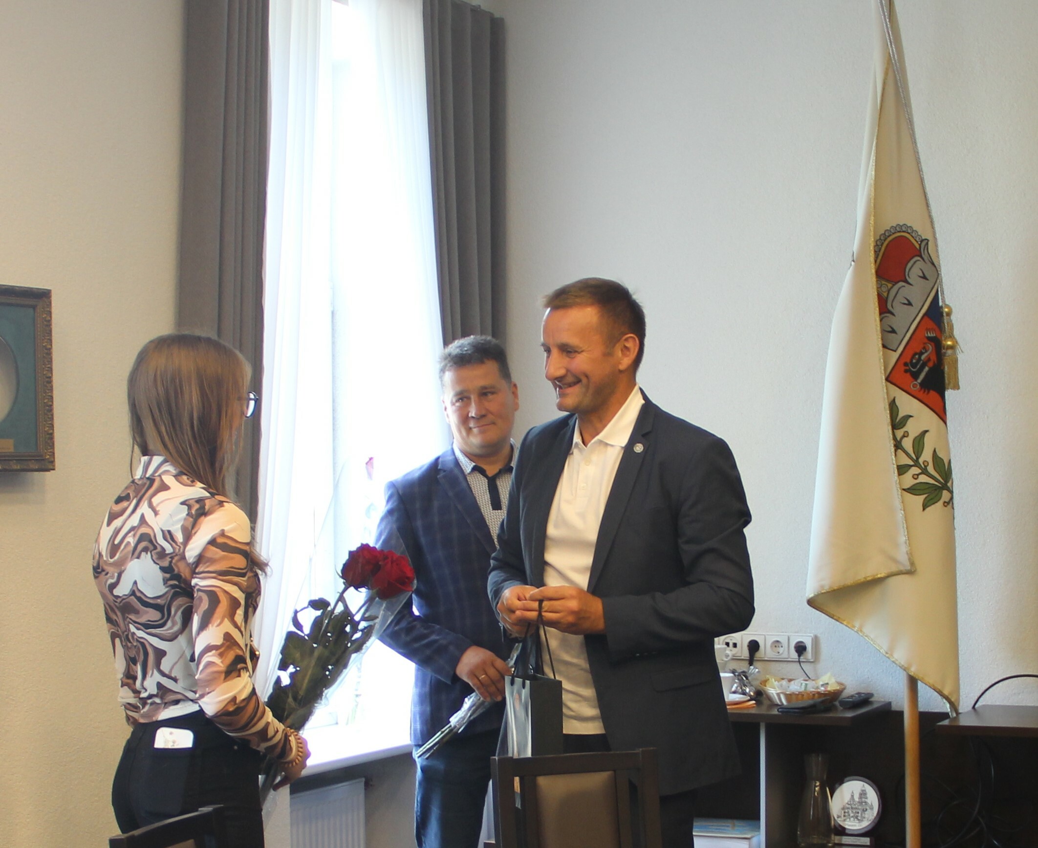 Šiaulių miesto meras įteikia gėles ir dovanas Patricijai Geriksonaitei.